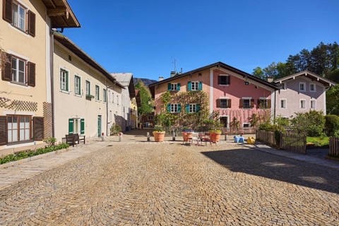 Sichlerhaus, historic building, facade, windows, shutters, square, cobblestones, trees, blue sky,