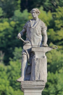Gunsmith by Georg Ringel as a symbol of the arms industry, anvil, manufacture, production, city