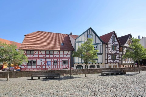 Colourful half-timbered houses, red, green, brown, empty benches, churchyard, Schmalkalden,