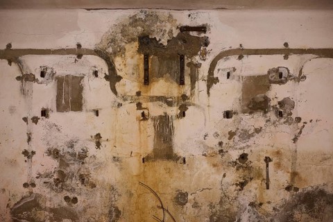 Lost Place, Ruin of a barracks, Dilapidated wall with old pipes and visible traces of weathering,
