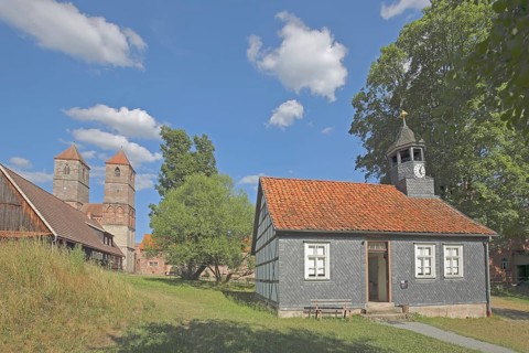 Parish hall with slate wall, spire and Romanesque St. Mary's Collegiate Church, church ruins,