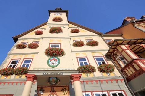 Town hall with view upwards, entrance with decorations and town coat of arms, view from below,