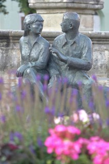 Bronze sculpture at the market fountain, modern art, male figure, female figure, couple, sitting,