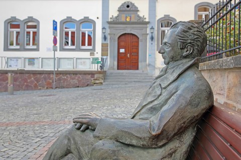 Johann Wolfgang von Goethe by Klaus Gutting sitting on the bench, arms, bronze sculpture, looking,