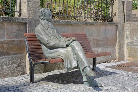 Johann Wolfgang von Goethe by Klaus Gutting sitting on the bench, bronze sculpture, looking, arms,