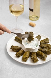 Dolma is served beautifully on a plate alongside a tangy yogurt dip, capturing the essence of home