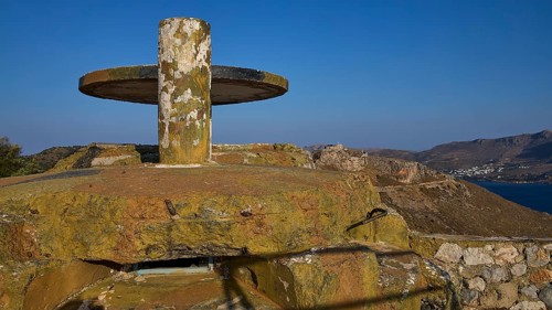 A weathered concrete platform on a hill with a sweeping sea view in a barren landscape, Lost Place,
