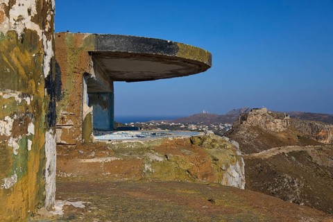 A dilapidated concrete bunker on a hill overlooking the coastal landscape, Lost Place, Lago