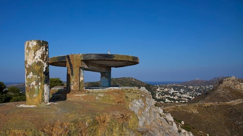 An abandoned concrete structure on a hill with a sweeping view over a cityscape, Lost Place, Lago