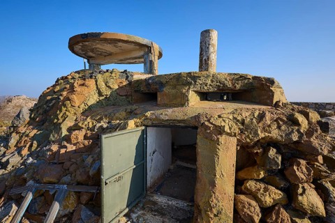 Abandoned bunker-like structure with rock walls and sky in the background, Lost Place, Lago
