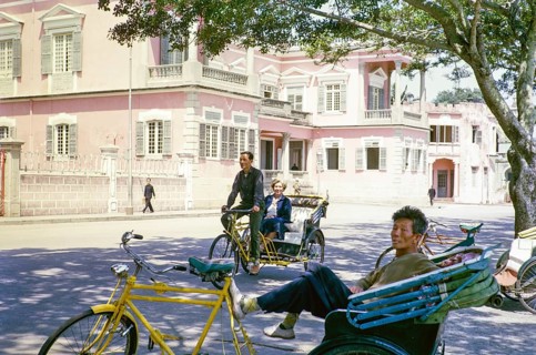 Tricycle rickshaw rider outside Governor's Palace, Portuguese colonial villa building, Avenida da