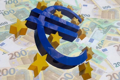 (Photomontage) euro sculpture cropped in front of euro banknotes