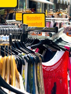 Summer dresses in bright colours on a clothes rack in a street sale in Wuppertal, Germany