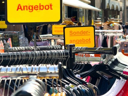 Summer dresses in bright colours on a clothes rack in a street sale in Wuppertal, Germany