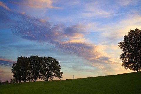 An impressive sky with colourful clouds at dusk over a green landscape, Siegen