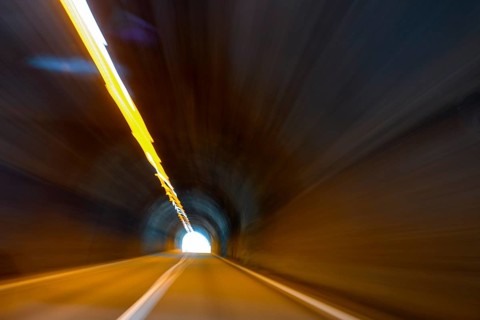 View from car while driving fast on car driver speeding car racer through long tunnel with straight