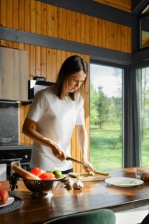 Preparing healthy dishes with fresh ingredients in a sunlit kitchen surrounded by nature