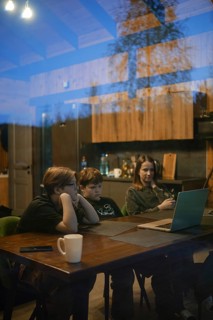 A cozy setting captures two children and an adult focused on a laptop screen inside a modern home.