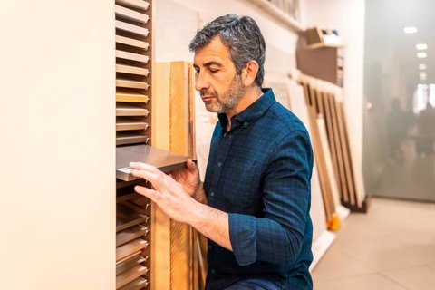 Carpenter selecting samples of wooden and metallic materials in a home improvement store for his