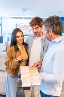 Couple choosing upholstery fabric from a wide variety of swatches held by a home improvement store