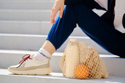 Essential food in reusable string bag on a stairs. Healthy living concept