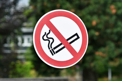 Red round 'No smoking' sign on glass wall