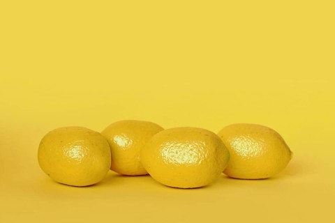 Lemon fruits on yellow background with copy space