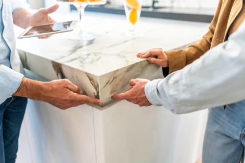 Architects examining a marble countertop joint in a home improvement store, discussing design