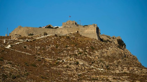 Historic castle on rocky peak surrounded by bright blue sky, Pandeli Castle, Castle, Leros