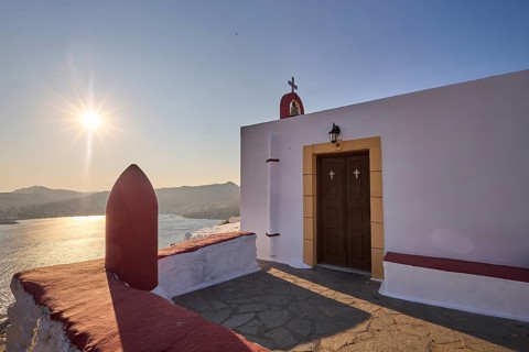 Chapel with a view of the sea at sunset, classic Mediterranean architecture, red-painted world war