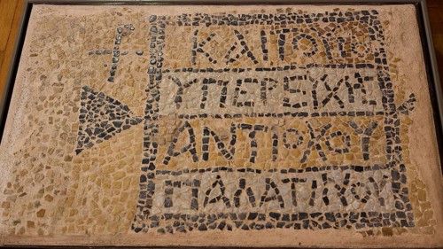 Ancient mosaic with ancient inscription and geometric patterns made of small stones, Archaeological