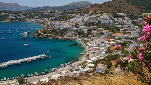 View of a Greek coastal town with flowers and yachts surrounded by blue sea, Pandeli Castle,