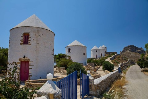 White windmills with red doors along a path under a clear sky on an island, Pandeli Castle, Castle,