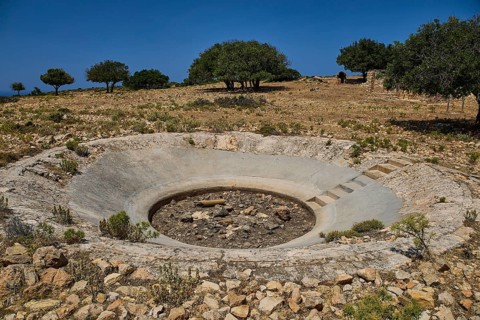 Round crater in a barren landscape with some trees on the horizon, Lost Place, Air Defence