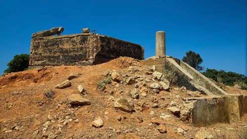 Old, crumbling structure on a desert-like terrain with rubble, Lost Place, Air Defence Position,