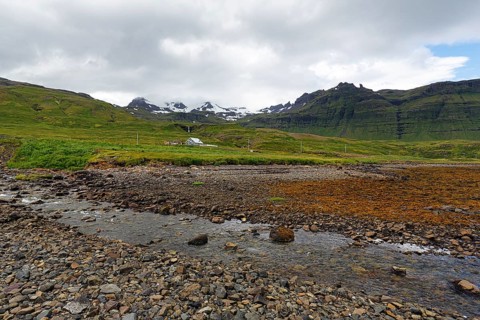 Rocky volcanic landscape near Grundarfjördur, snow-capped mountains on the horizon, Snæfellsnes