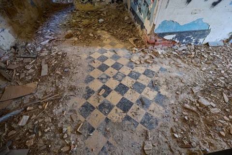 Lost Place, chequered pattern on the floor of a dilapidated room, surrounded by rubble and blue