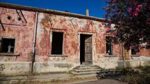 Lost Place, Dilapidated building with peeling plaster, surrounded by flowering tree under clear