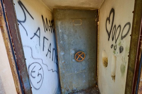 Lost Place, Small room with graffiti-covered metal door and worn appearance, Radio Station, WW2,