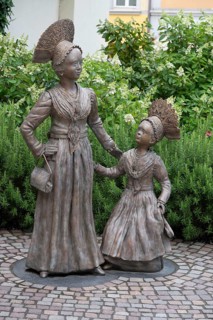 Two bronze sculptures, Überlingen women in festive traditional costume, created in 2023 by the