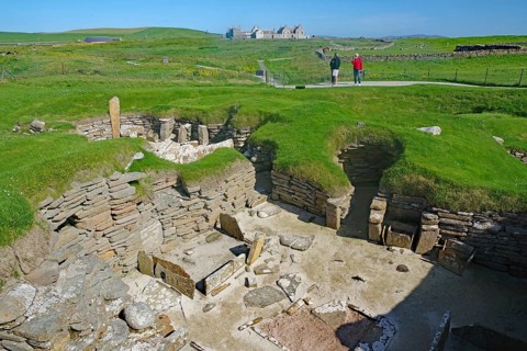 Wide view of an archaeological site with ruins in grassy landscape, Skara Brae, Neolithic