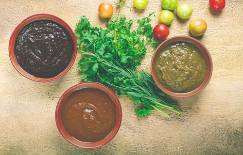 Set of tkemali sauces, three types of tkemali sauce, in ceramic bowls, top view, Georgian cuisine,