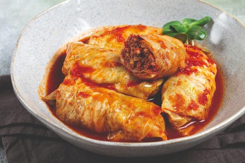 Stuffed cabbage rolls with minced meat, in tomato sauce, top view, without people, in the spotlight
