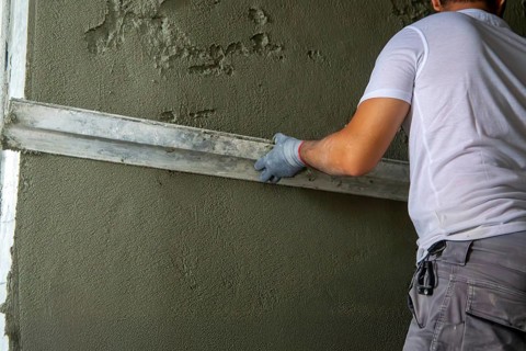 Plasterer smoothing interior walls