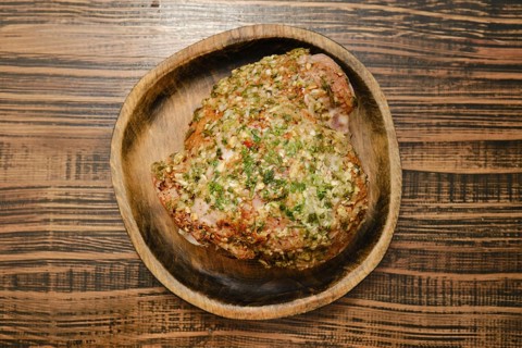 A flavorful turkey thigh is beautifully seasoned with a blend of aromatic herbs, displayed on a