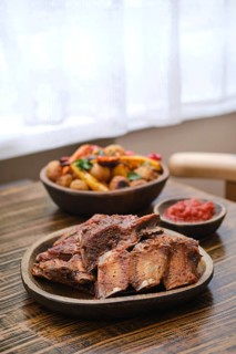 Succulent short beef ribs are freshly roasted in the oven, presented on a rustic plate