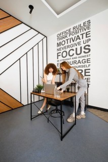Two women work together in a stylish office dedicated to women's health, discussing plans and