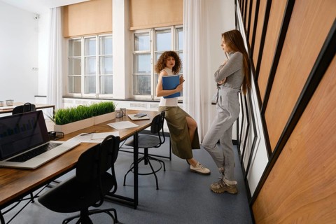 Two women are discussing the user interface of their health monitoring app in a stylish startup