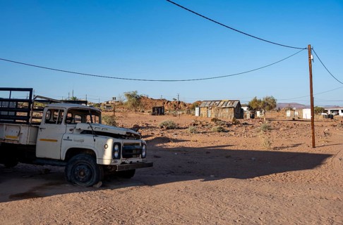 Old transport vehicle and simple houses made of wood and mud in a small village, Erongo,
