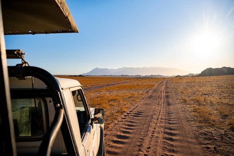 View from a safari vehicle, sandy track in desert landscape, in the evening light, Brandberg,